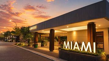A modern building with a 'CLUBHOUSE' sign and 'MIAMI' illuminated sign.