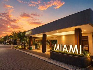 A modern building with a 'CLUBHOUSE' sign and 'MIAMI' illuminated sign. - Lavena By SanLiving - 2BR - PIK2 (Banten)