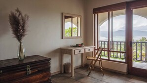 A room with a wooden dresser, a desk with drawers, a chair, a mirror, and a large window with a view. - Barton Hammerkop Villa nr Hermanus - HotTub & Pool (Bot River)