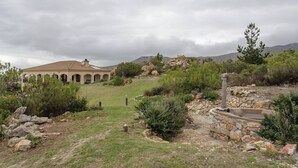 A building with a dome roof and arches, surrounded by a landscaped garden with a stone pathway and a small pool. - Barton Hammerkop Villa nr Hermanus - HotTub & Pool (Bot River)