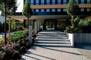 Ein modernes Gebäude mit einer Steintreppe, die zu einem Glas Eingang führt.