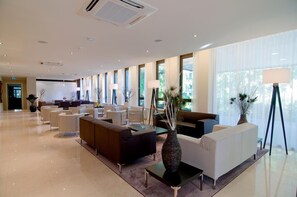Eine großzügige Lobby mit modernen Sitzgelegenheiten, großen Fenstern und einem hellen, sauberen Innenraum.