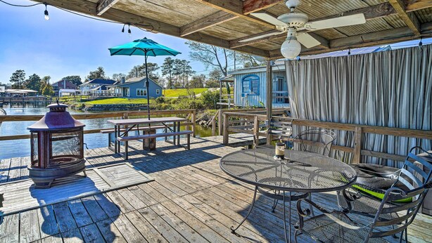 Une terrasse en bois avec des sièges d’extérieur, une table et une lanterne.