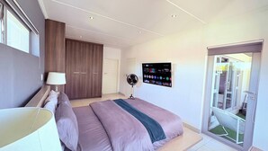 Makuuhuoneessa on sänky, seinälle asennettu televisio, vaatekaappi ja uloskäyntiä varten liukuovi.