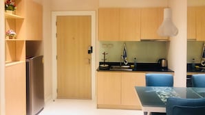 Eine moderne Küche mit Holzausbau, einem Edelstahlkühlschrank, einer Spüle und einem Esstisch mit Stühlen.