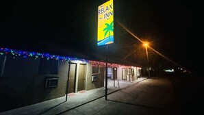 A building with a sign reading 'RELAX INN' and a palm tree symbol, indicating a hotel or inn. - 2 Full Beds Non-Smoking (Sulphur LA)