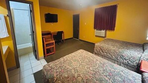 A room with two beds, a desk, a chair, a television, and a door. - 2 Full Beds Non-Smoking (Sulphur LA)