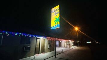 A building with a sign reading 'RELAX INN' and a palm tree symbol, indicating a hotel or inn.