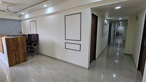 A hallway with a reception desk, office chairs, and framed pictures on the walls.