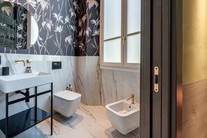 Un baño con lavamanos blanco, inodoro y bidé.