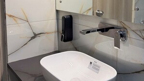 Un bany amb un rentapins blanc, un mirall i una làmpada.