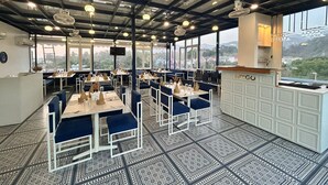 Un restaurant amb un sostre alt, grans finestres i un paviment amb disseny.
