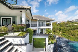 A modern two-story house with a swimming pool, a staircase leading to the entrance, and a view of the surrounding landscape. - Villa Ocean's Height By Fays Hospitality (Bali)