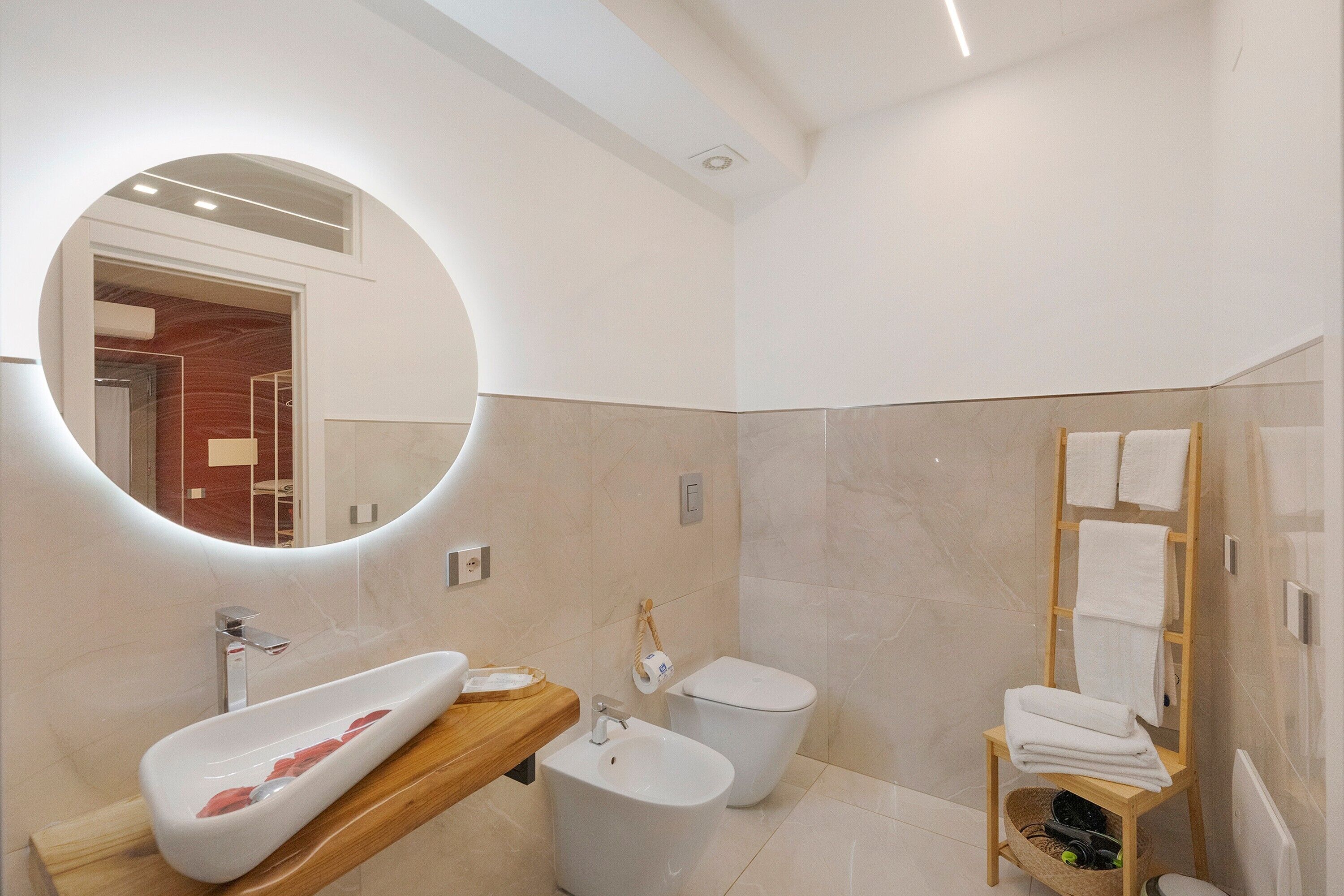 Un baño moderno con una bañera independiente, un lavamanos y un inodoro.