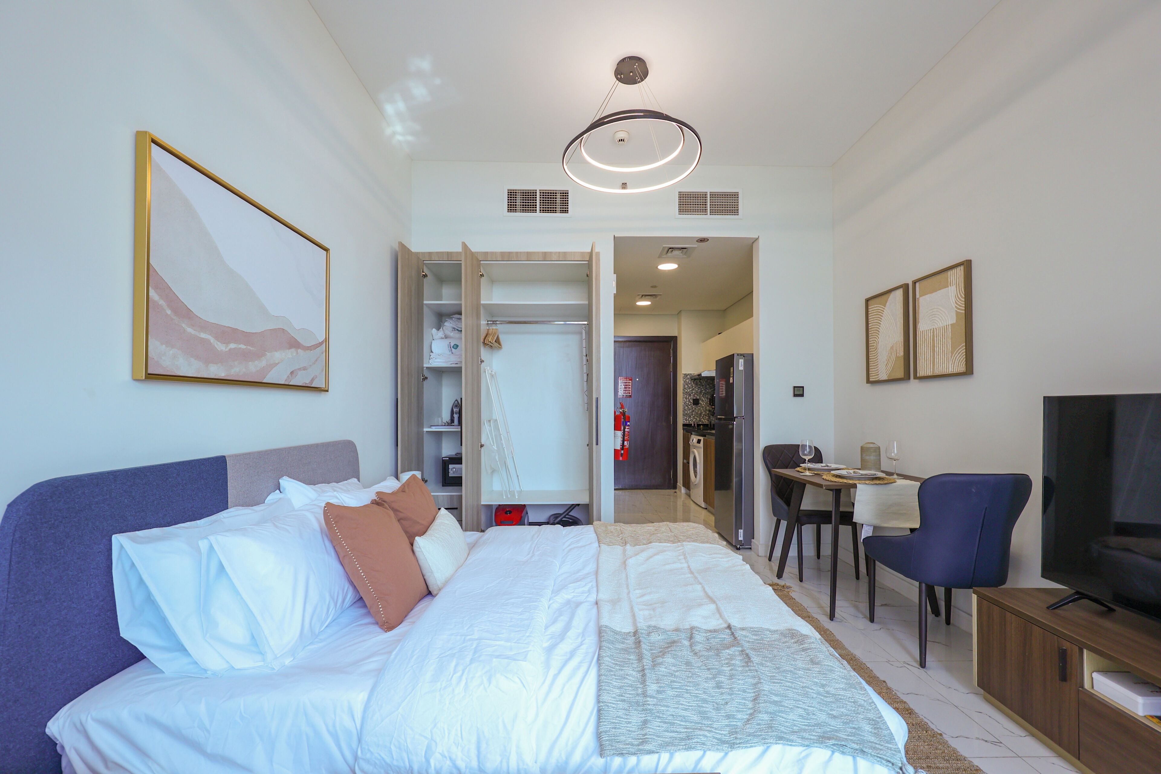 Quarto com cama, televisão, escrivaninha e cadeira.
