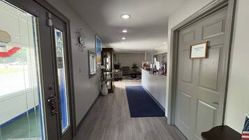 A hallway with a reception desk, a door labeled 'Employees Only,' and a potted plant.