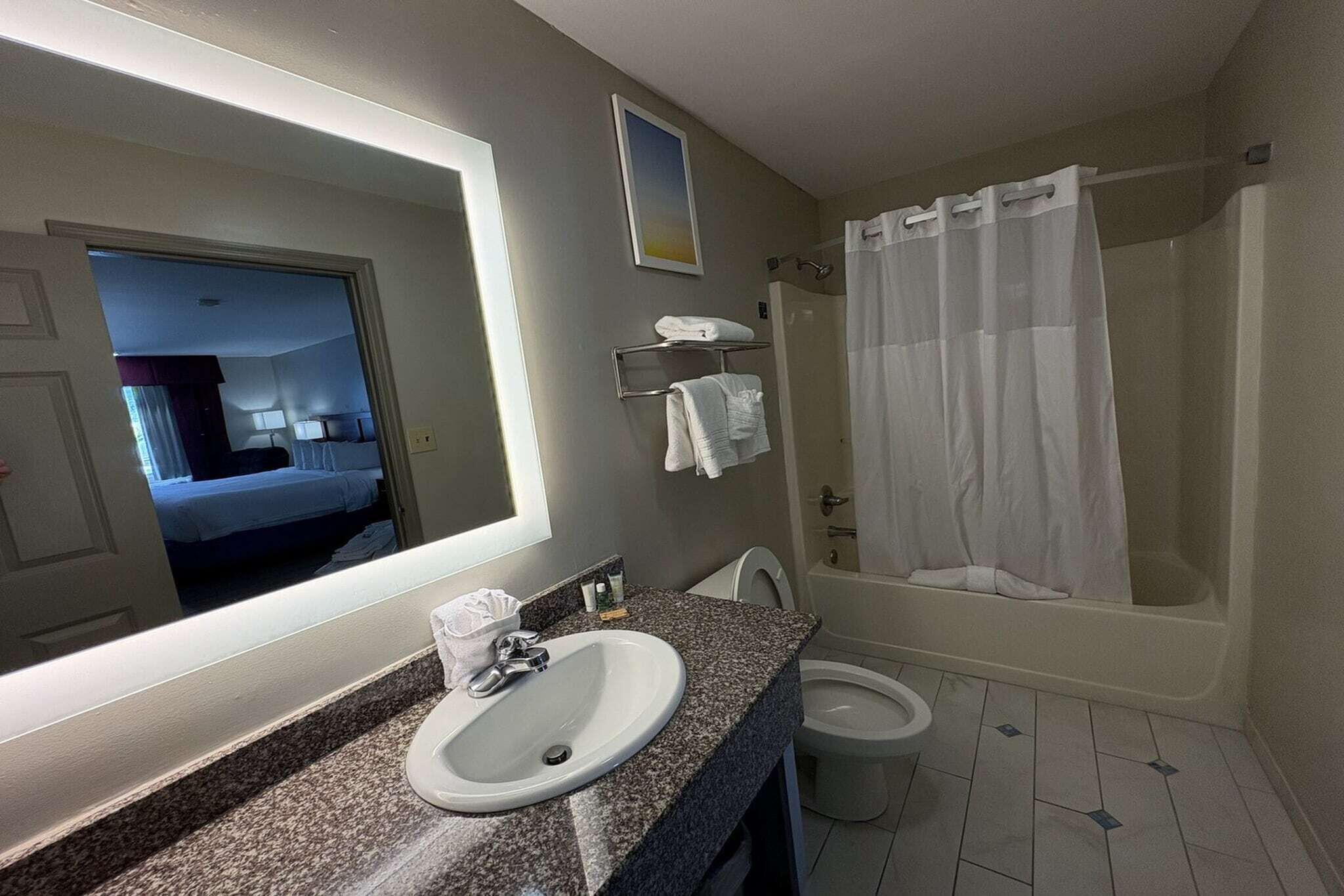 A bathroom with a sink, toilet, and shower.