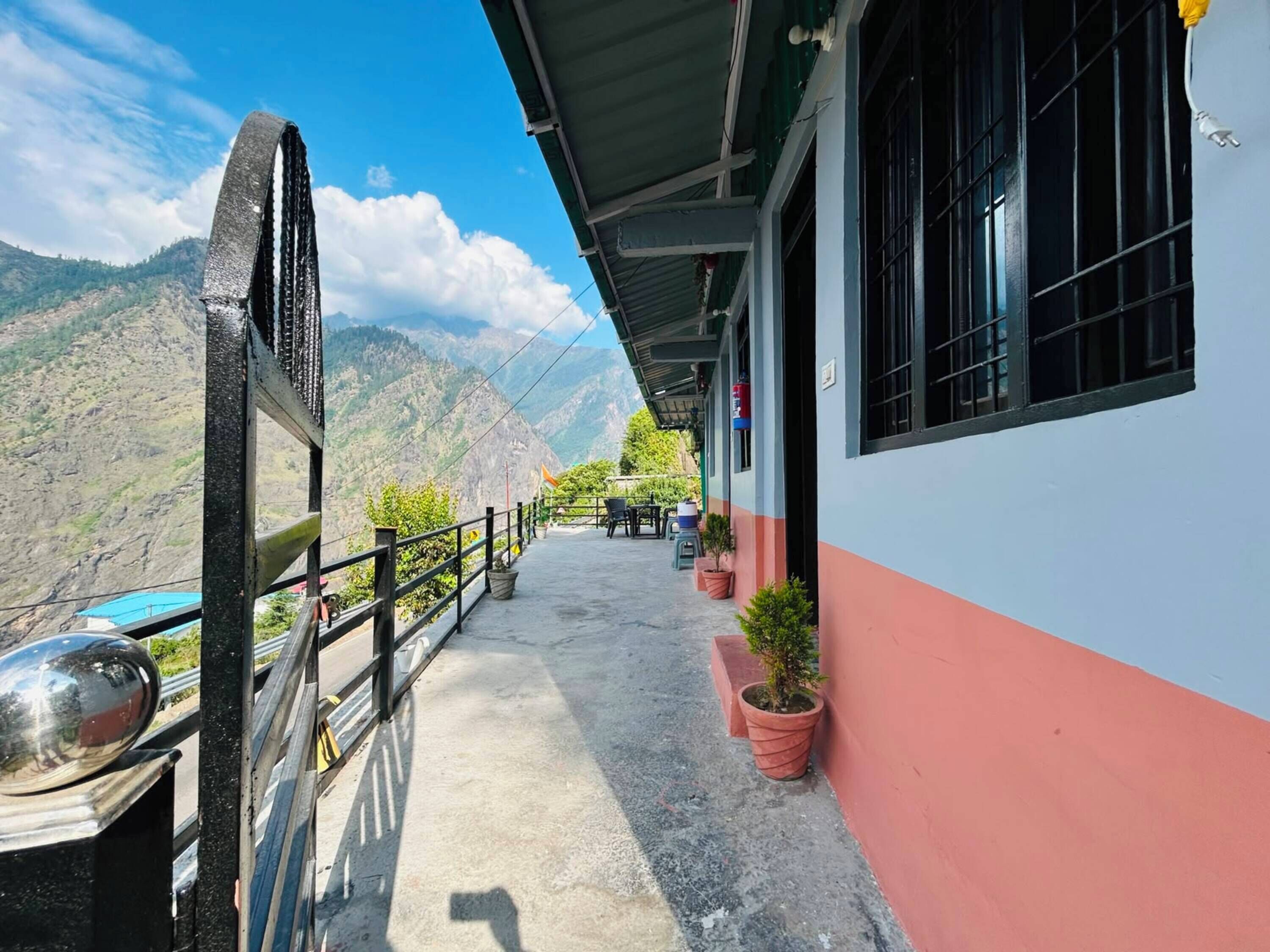 Un edificio con balcón que da a un paisaje montañoso.