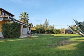 A residential property with a well-maintained lawn, a patio area, and a parked car.