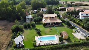 An aerial view of a residential area with a swimming pool, a covered patio, and surrounding greenery. - Apartment 'Masone Verde' with Shared Pool, Wi-Fi and Air Conditioning (Castiadas)
