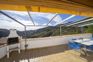 A terrace with a grill, blue chairs, and a table. - 4-Guest Laroya Cottage with Pool (Laroya)