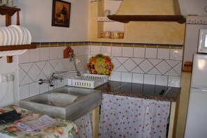 A kitchen with a sink, a fruit bowl, and a microwave. - 4-Guest Laroya Cottage with Pool (Laroya)