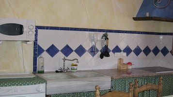 Een keuken met een wasmachine, een spoelbak en een magnetron.