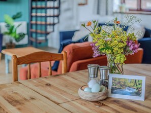 Une table en bois sur laquelle se trouvent un bol d’œufs, des salières et des poivrières, et une photo encadrée.