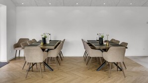 Un salón de conferencias con una larga mesa, varias sillas y una pizarra.