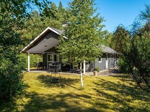 A house with a covered patio, a barbecue area, and a lawn. - "Laris" -  from the sea by Interhome (Hadsund)