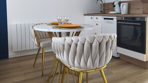 A modern kitchen with white cabinets, a built-in oven, and a coffee maker. - Le Saphir d'Ault—The beach is 100 meters away, and restaurants are just a stone's throw away (Ault)