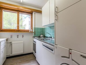 A kitchen with white cabinets, a window, a radiator, and a Kenmore refrigerator. - Cresta Appartement/Fewo 4-Bettwohnung Nr. 6 by Interhome (Saas-Fee)