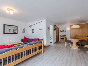 A modern living room with a wooden bench, a dining table, and a kitchen area with wooden cabinets. - Cresta Appartement/Fewo 4-Bettwohnung Nr. 6 by Interhome (Saas-Fee)