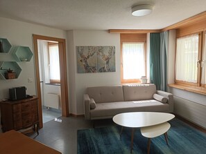 Ein modernes Wohnzimmer mit einer Couch, einem Couchtisch und einem Gemälde an der Wand.