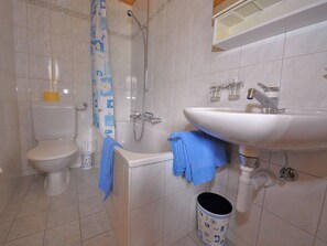 A bathroom with a toilet, a shower, a sink, and a trash bin. - Chalet Ideal Appartement/Fewo 3-Bettwohnung Nr. 4 by Interhome (Saas-Fee)