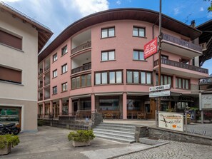 A multi-story building with balconies, a sign for 'Generali,' and a sign for 'Parnucchiere Francesco.' - Condominio Europa N27 by Interhome (Bormio)