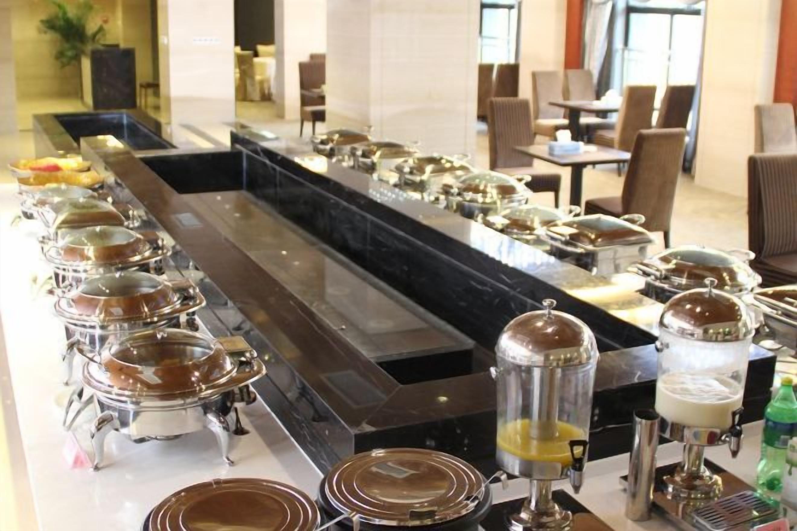 A buffet setup with multiple food stations and a coffee machine.