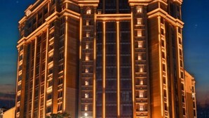 A multi-story hotel with a symmetrical facade, large windows, and a central vertical feature.