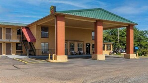A motel with a covered parking area, a staircase, and a sign indicating a restaurant. - 2 Queen Bed | Smoking (Forest City, AR)