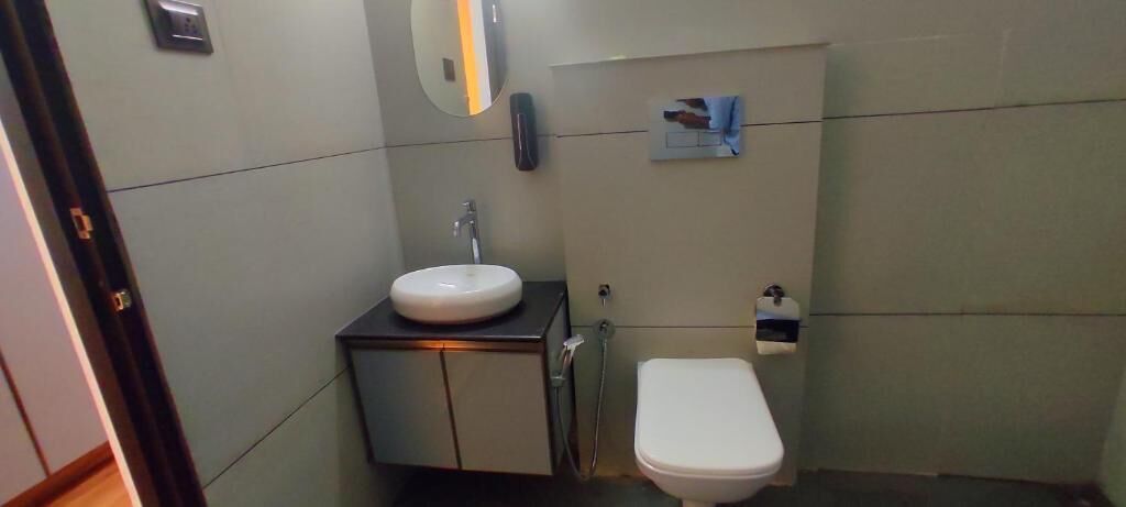 Un baño pequeño con un lavamanos blanco, un inodoro y un espejo.