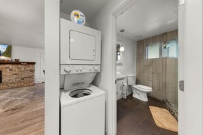 A laundry area with a washing machine and dryer, a toilet, and a sink. - Tahoe Lake & Mountain Retreat (Carnelian Bay)