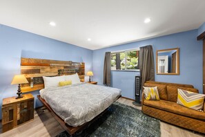 A bedroom with a bed, bedside tables, a sofa, a window with curtains, and a mirror on the wall. - Tahoe Lake & Mountain Retreat (Carnelian Bay)