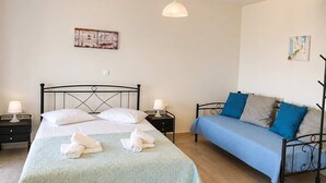 Ein Schlafzimmer mit einem Bett, einer Couch, zwei Nachttischen und einer Hängeleuchte.