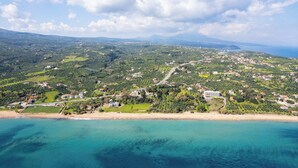 Eine Küstenstadt mit Strand, Häusern und viel Grün.