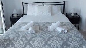 Un lit bien fait, recouvert d’une couvre-lit à motifs, deux tables de chevet avec des lampes et un tableau accroché au mur.