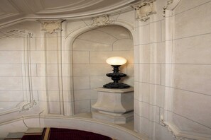 A room with a marble wall, a decorative light fixture, and a red carpet. - Luxurious suite - AC- 2P- Madeleine/Saint Honore (Paris)