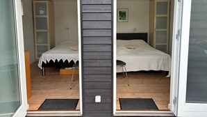 Una habitación con cama, una silla, un armario y una puerta.