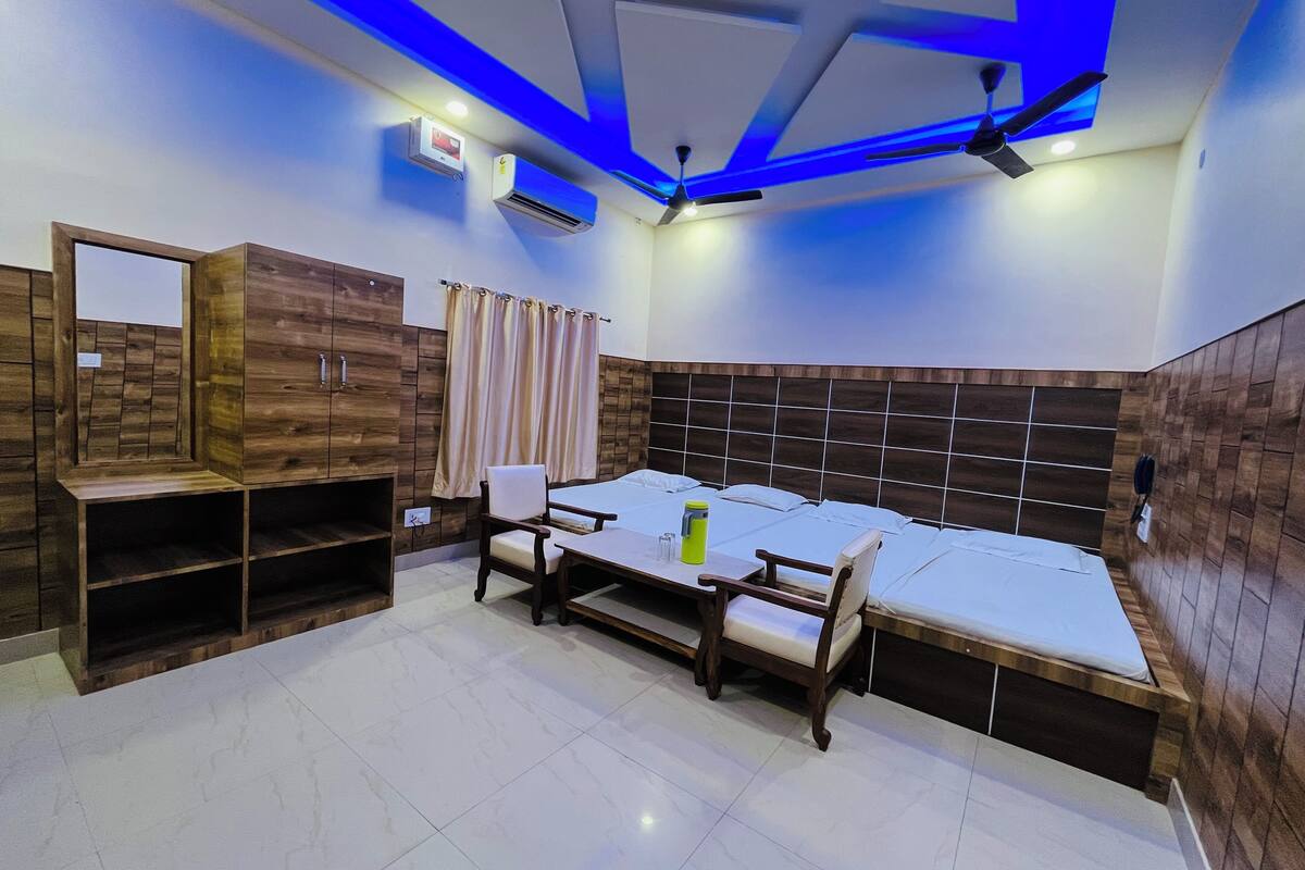 A room with a bed, a desk, a chair, a wardrobe, and a ceiling fan.