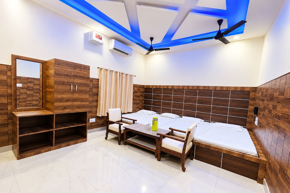 Una habitación de hotel con una cama, un escritorio, una silla, un armario y un ventilador de techo.