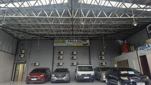 A car wash facility with multiple cars, a metal roof, and air conditioning units. - Smart Solo Stay Near RSUD Haji (Makassar)